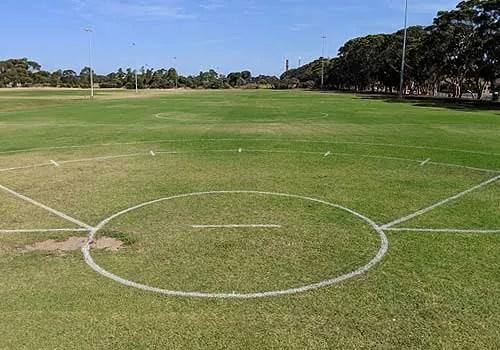 Freshly painted centre circle and centre square lines on a grass sports oval